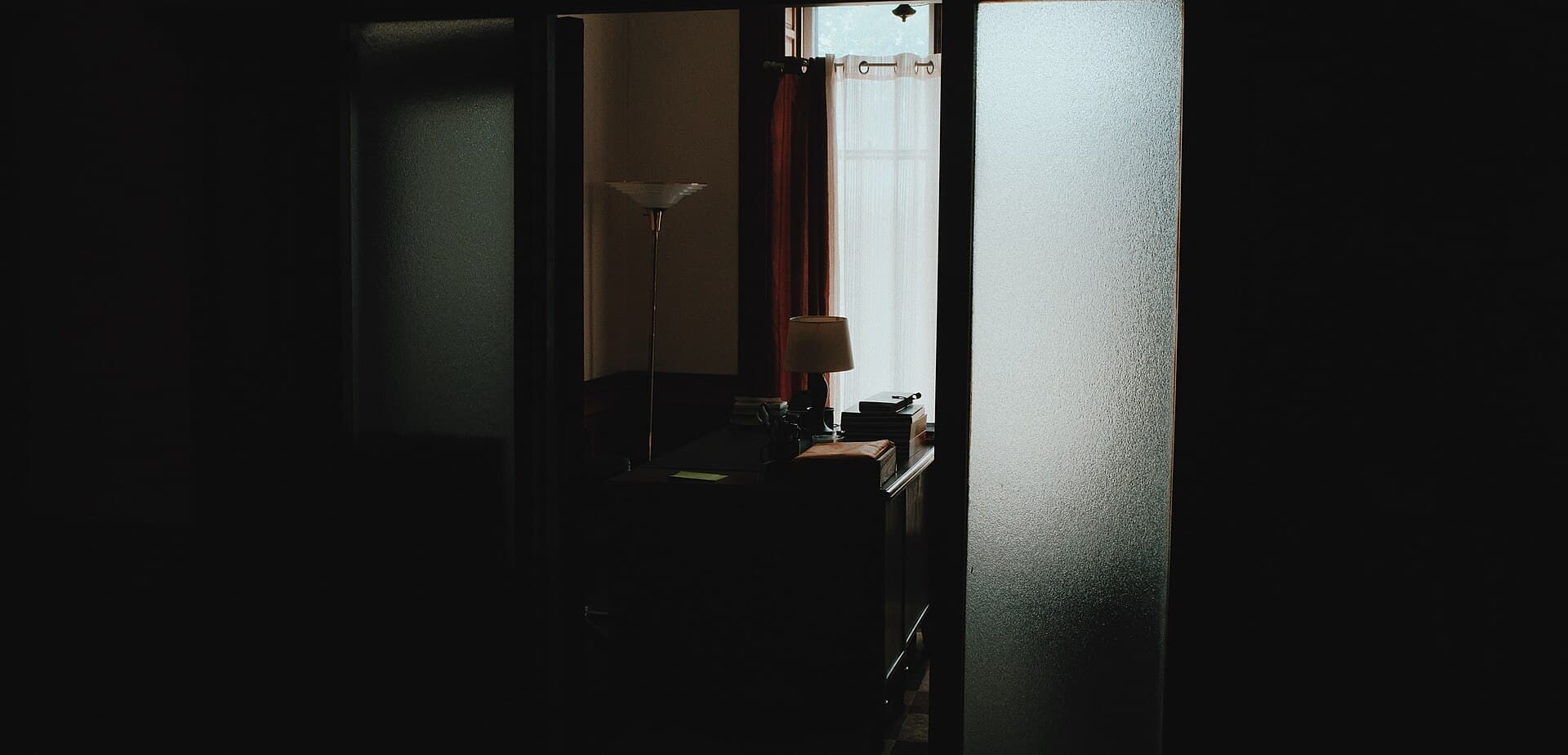 A quiet room with an open doorway and a desk beyond it